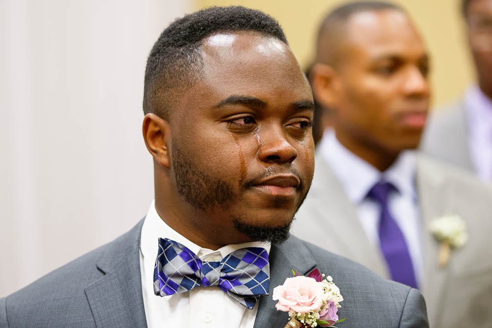 candid shot of groom crying when he discover bride