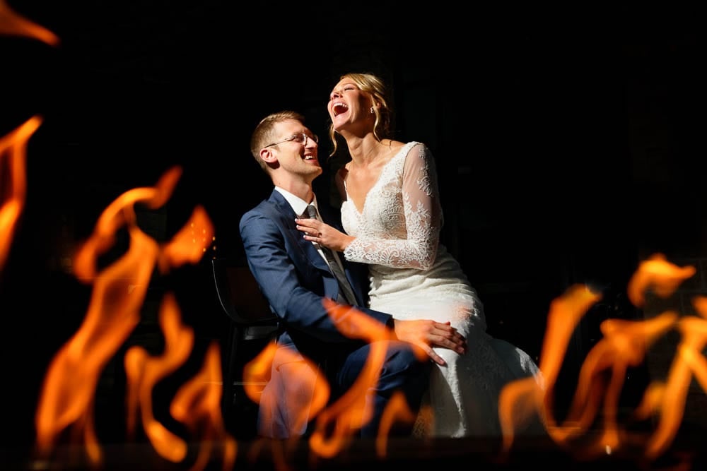 picture of bride and groom having fun with flames on black background