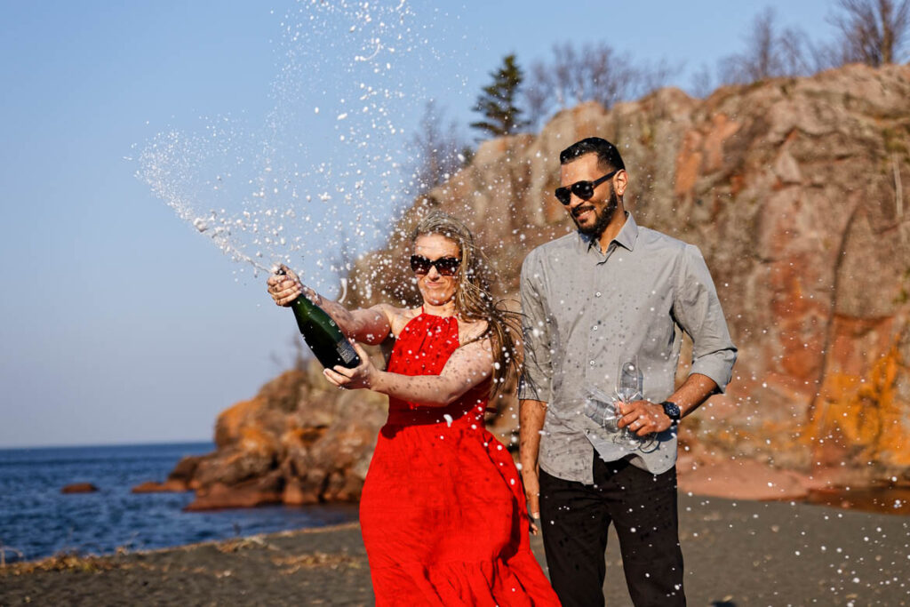 engagment session couple poping bottle of champagne