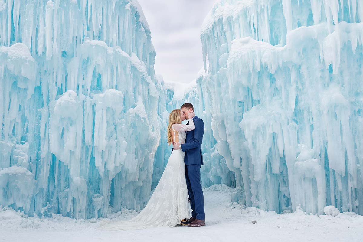 ice-castle-photo-session-bride-and-groom-kissing-with-giant-ice-falls-walls