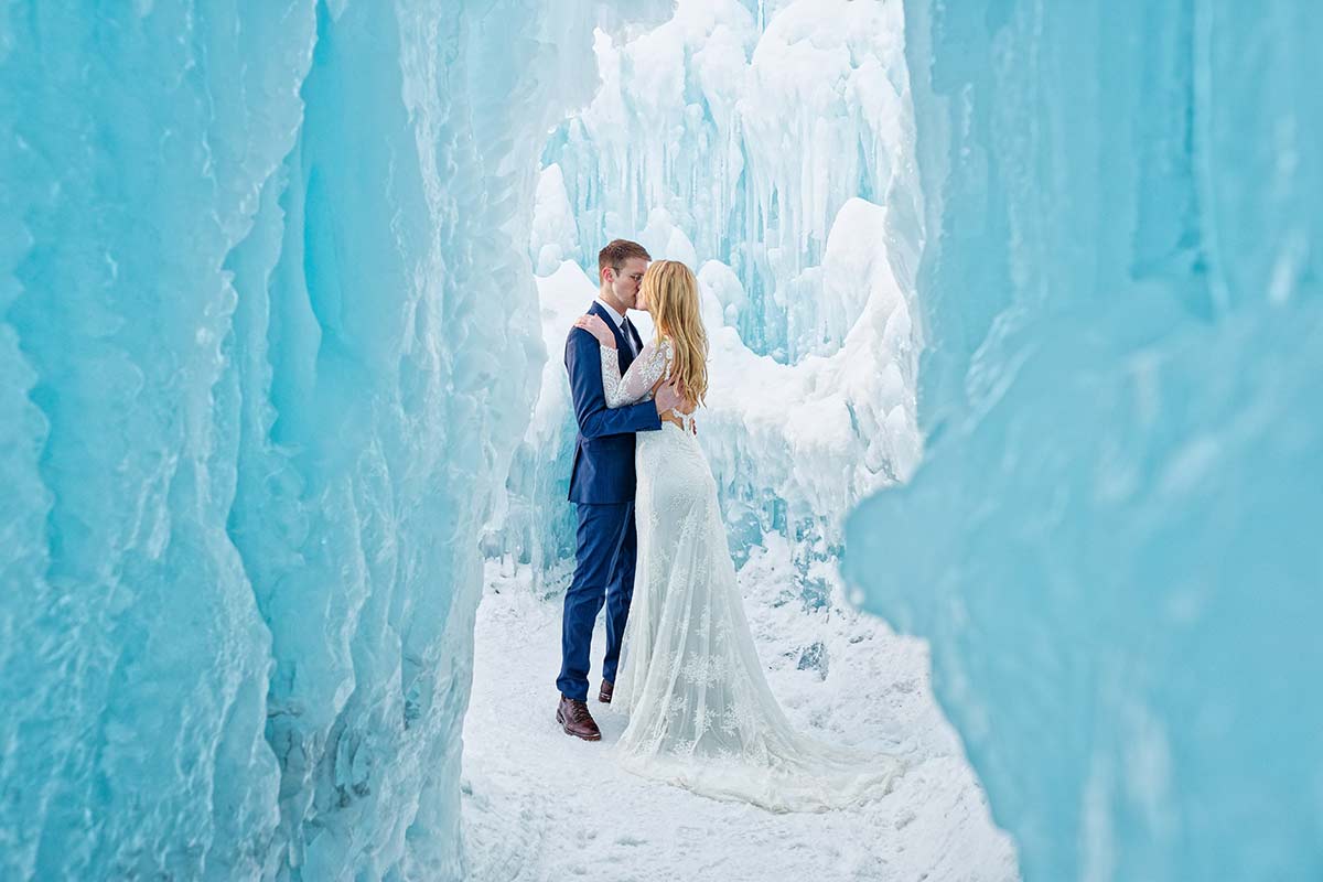 photo-of-the-couple-kissing-taken-from-the-cave-of-the-ice-castle-with-blue-ice