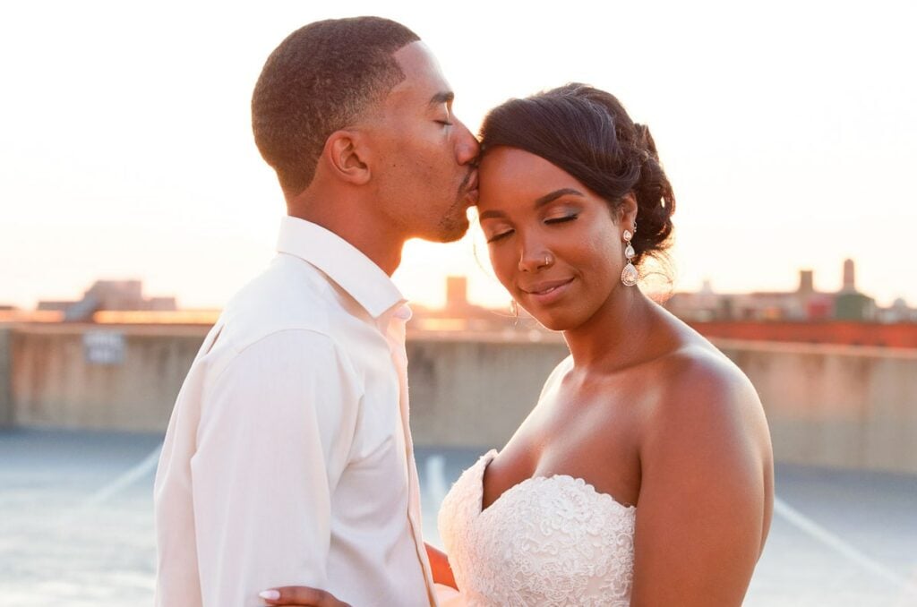 bride and groom kissing sunset rooftop