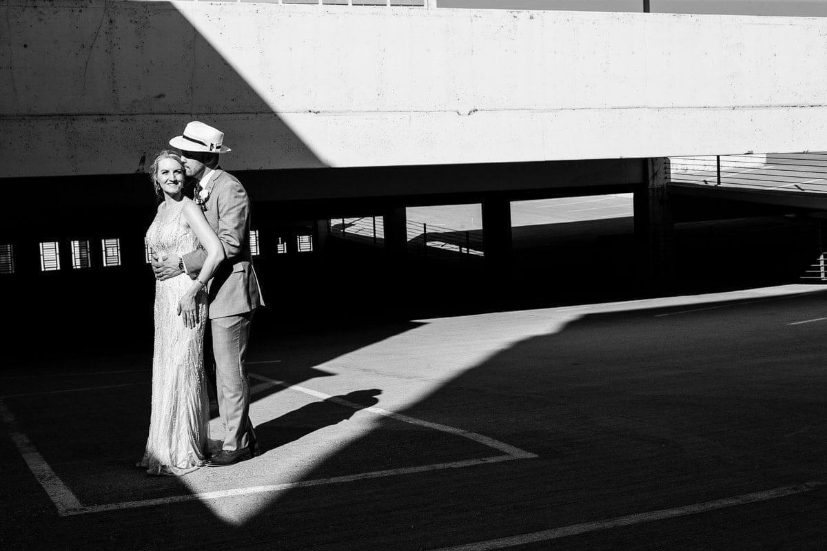 black and white image on rooftop bride and groom in sun ray