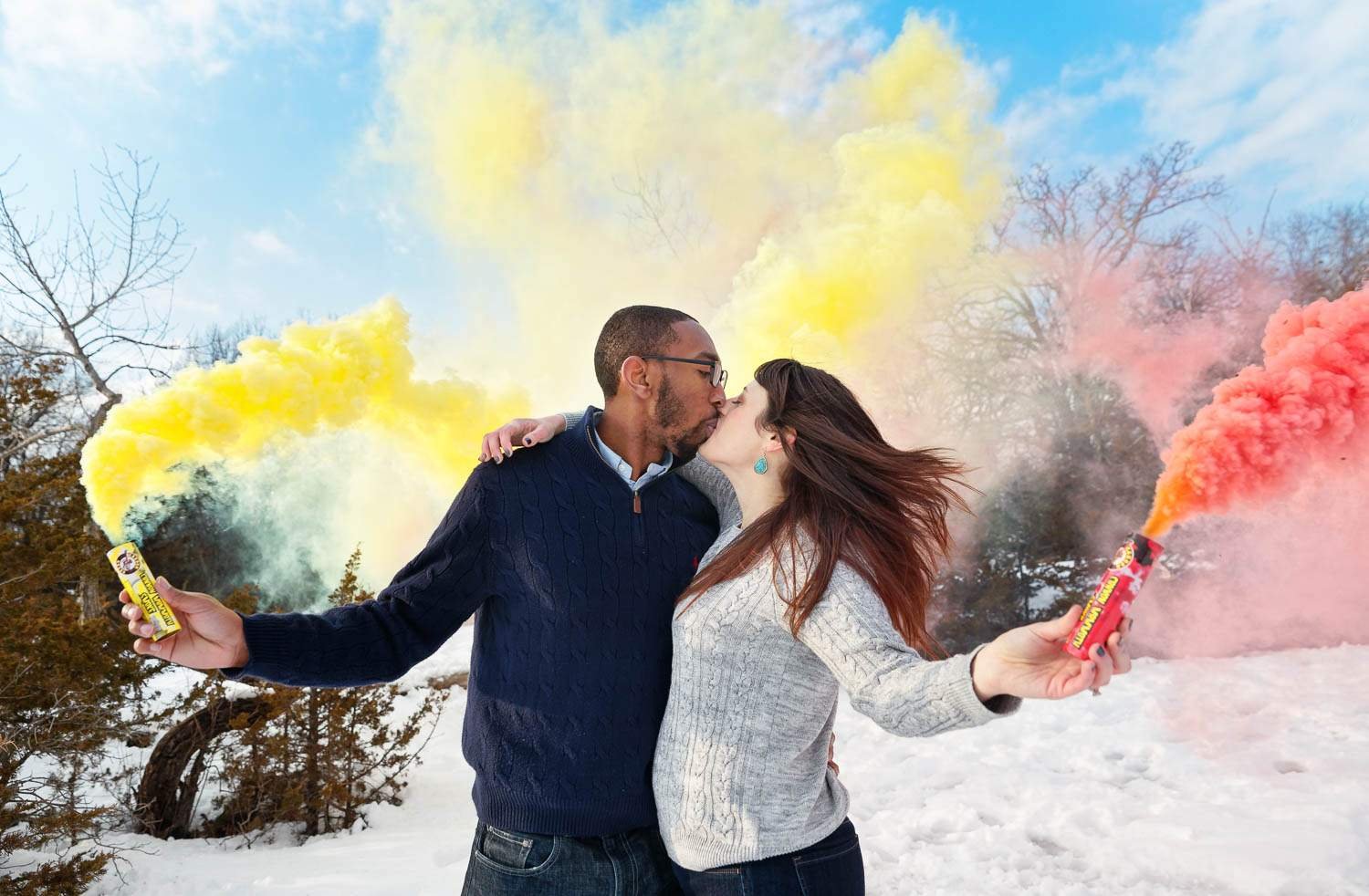 couple kissing using yellow red smoke bomb