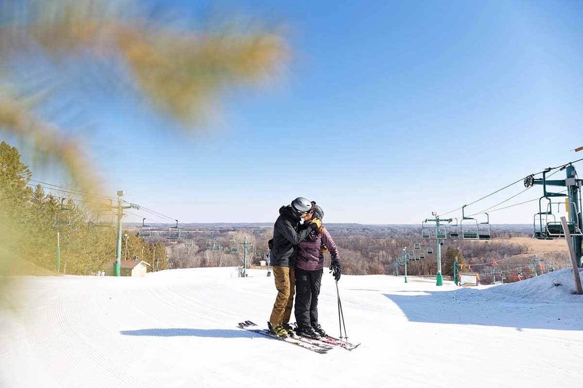 couple-in-ski-at-the-top-of-the-hill-kissing-view-on-minnesota