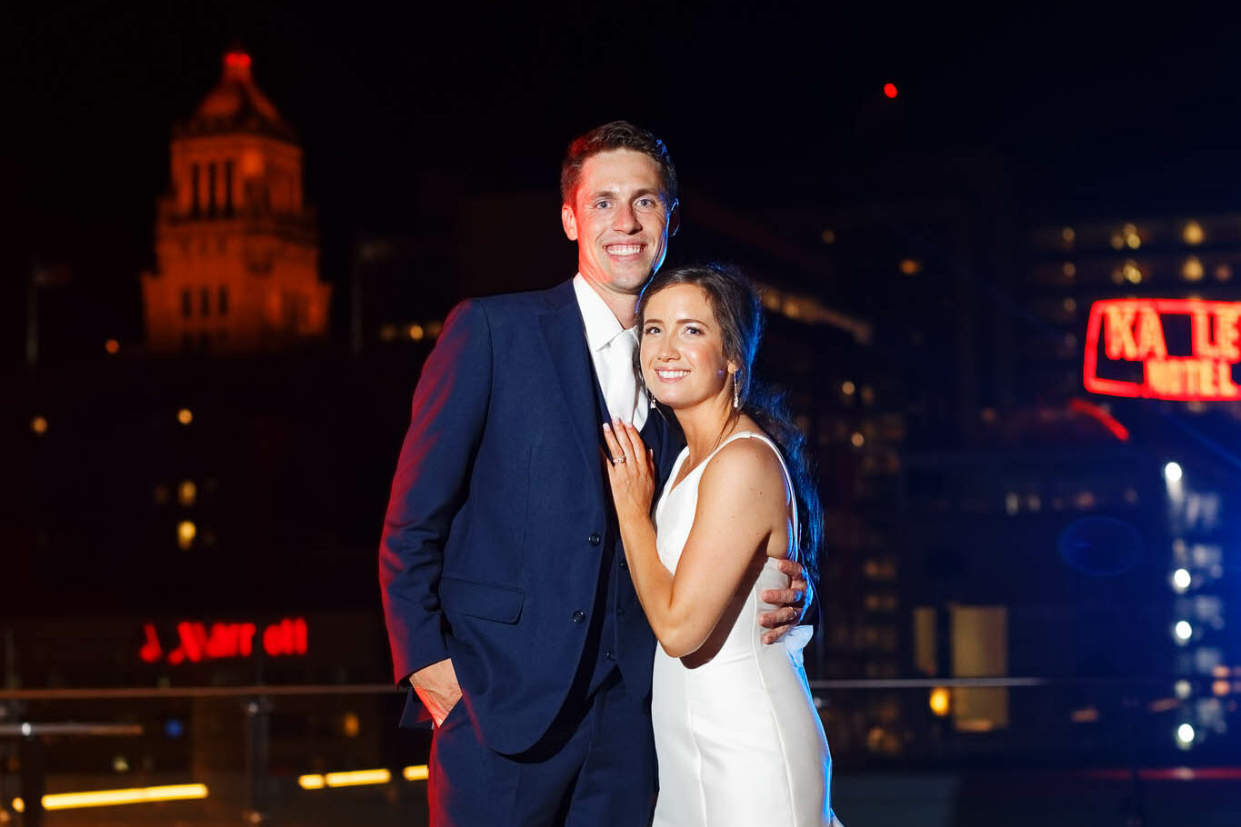 night portrait of newly married couple with view on Rochester city plummer building carillon and the Kahler Grand Hotel neon Sign
