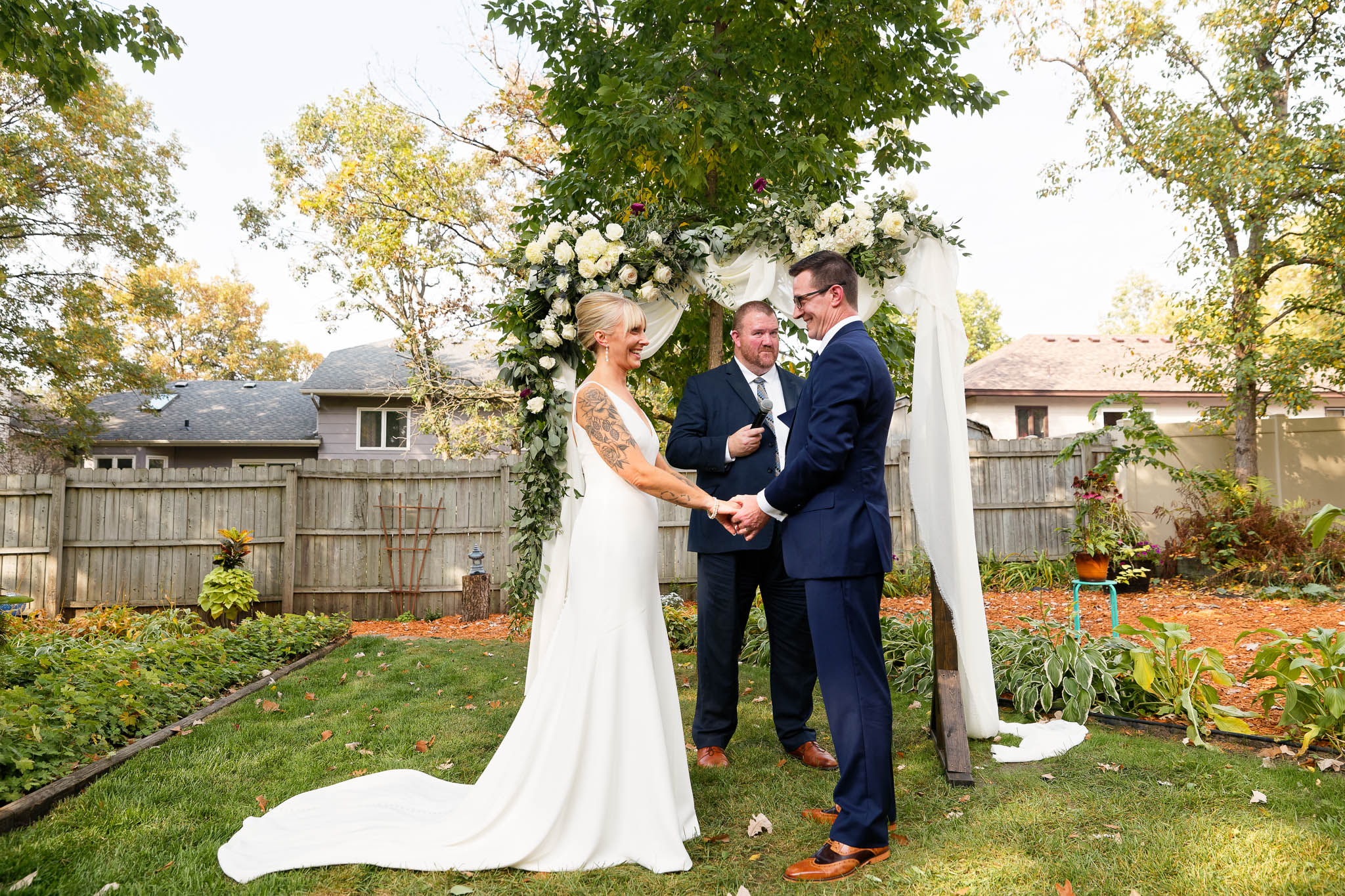 backayrd wedding ceremony in fornt wedding arch