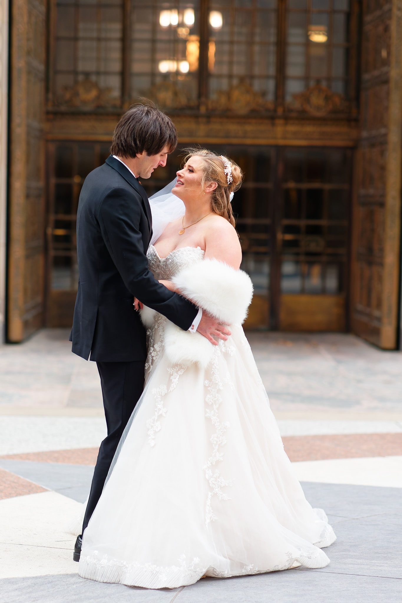Bride and groom portrait in front of the plummer building's copper door