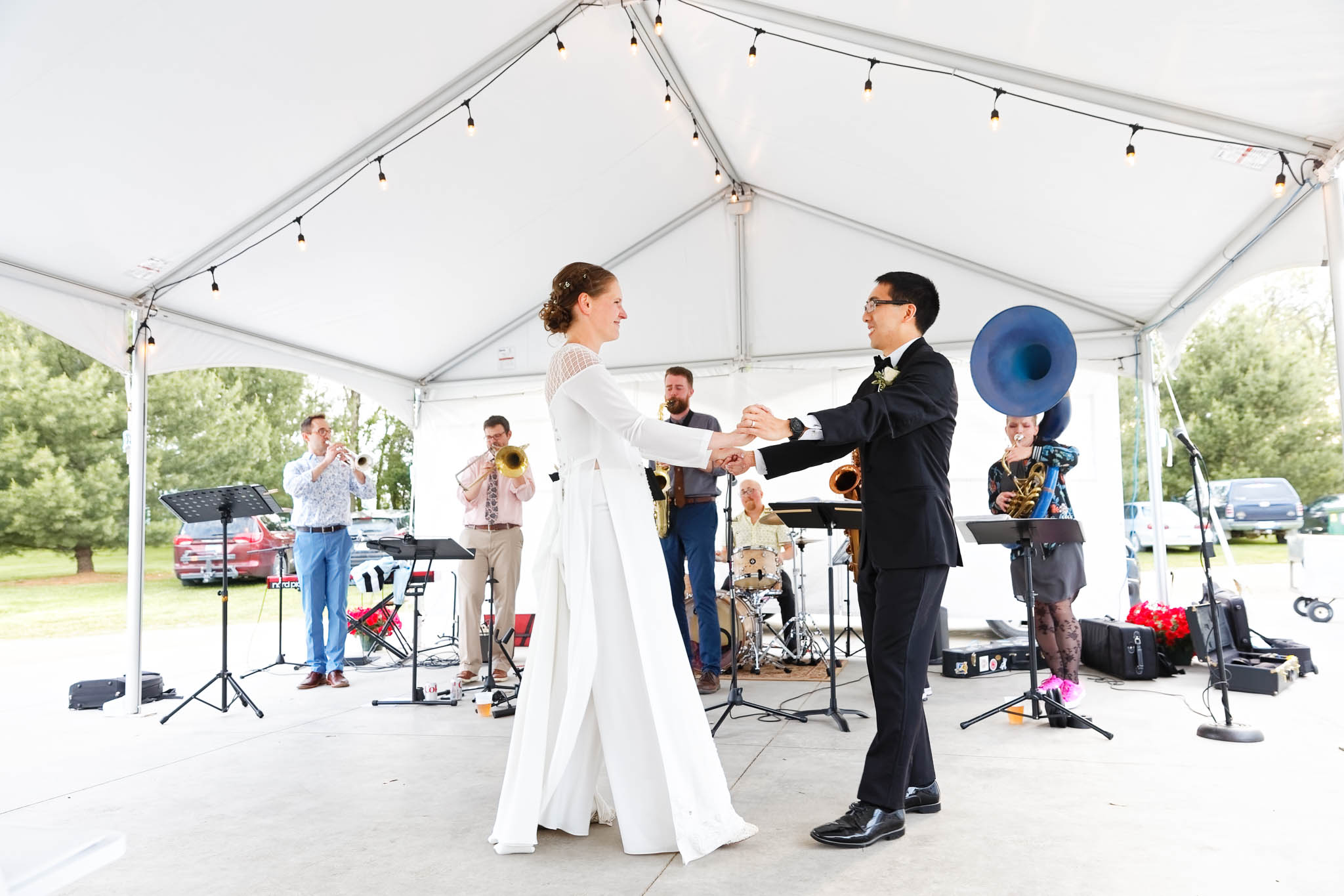bride and groom first dance under the tent with live music