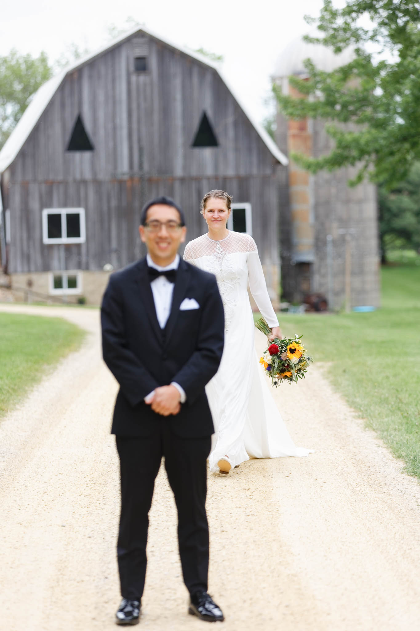 bride and groom first look with barn in the back