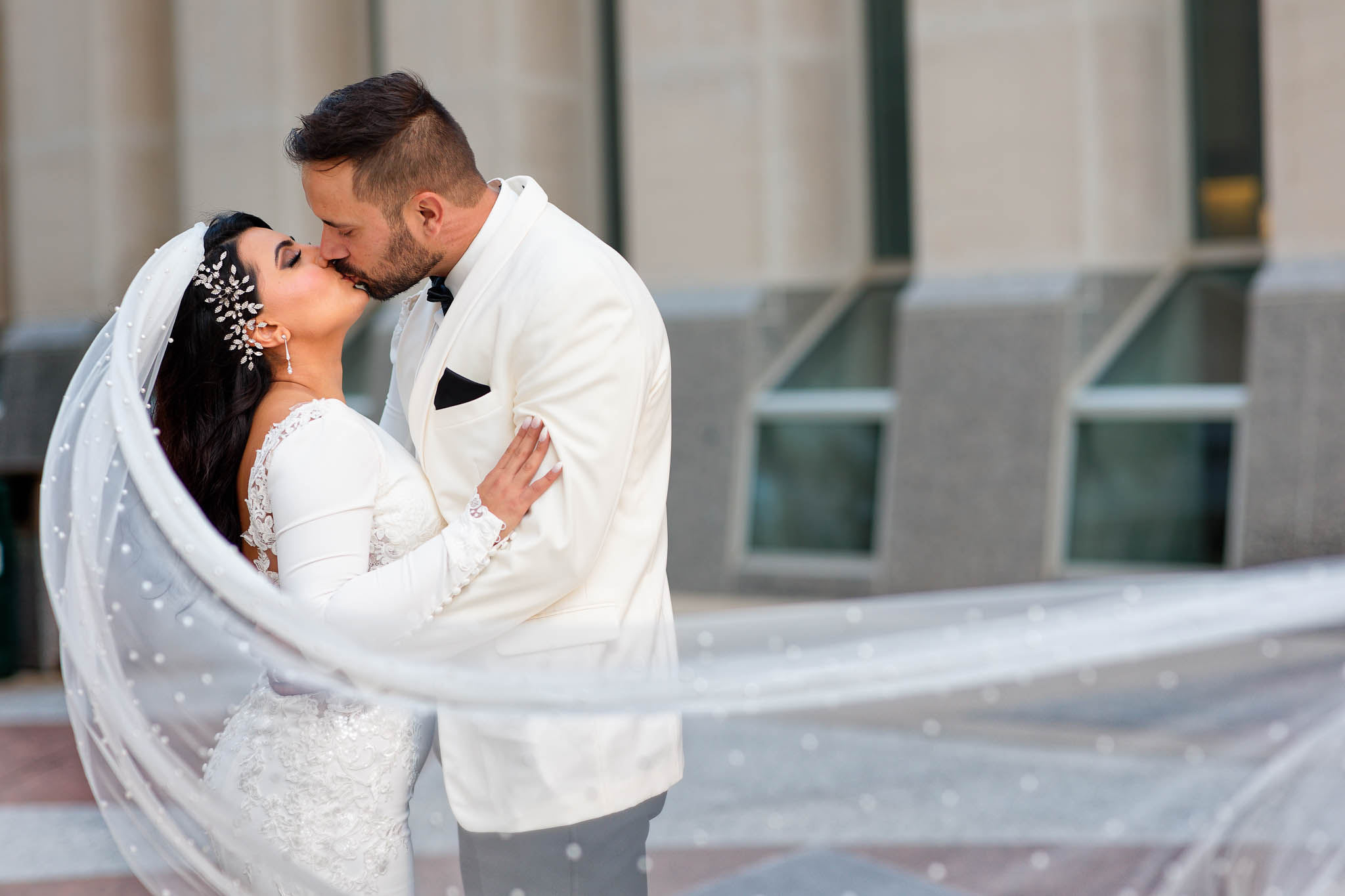bride and groom kissing long veil