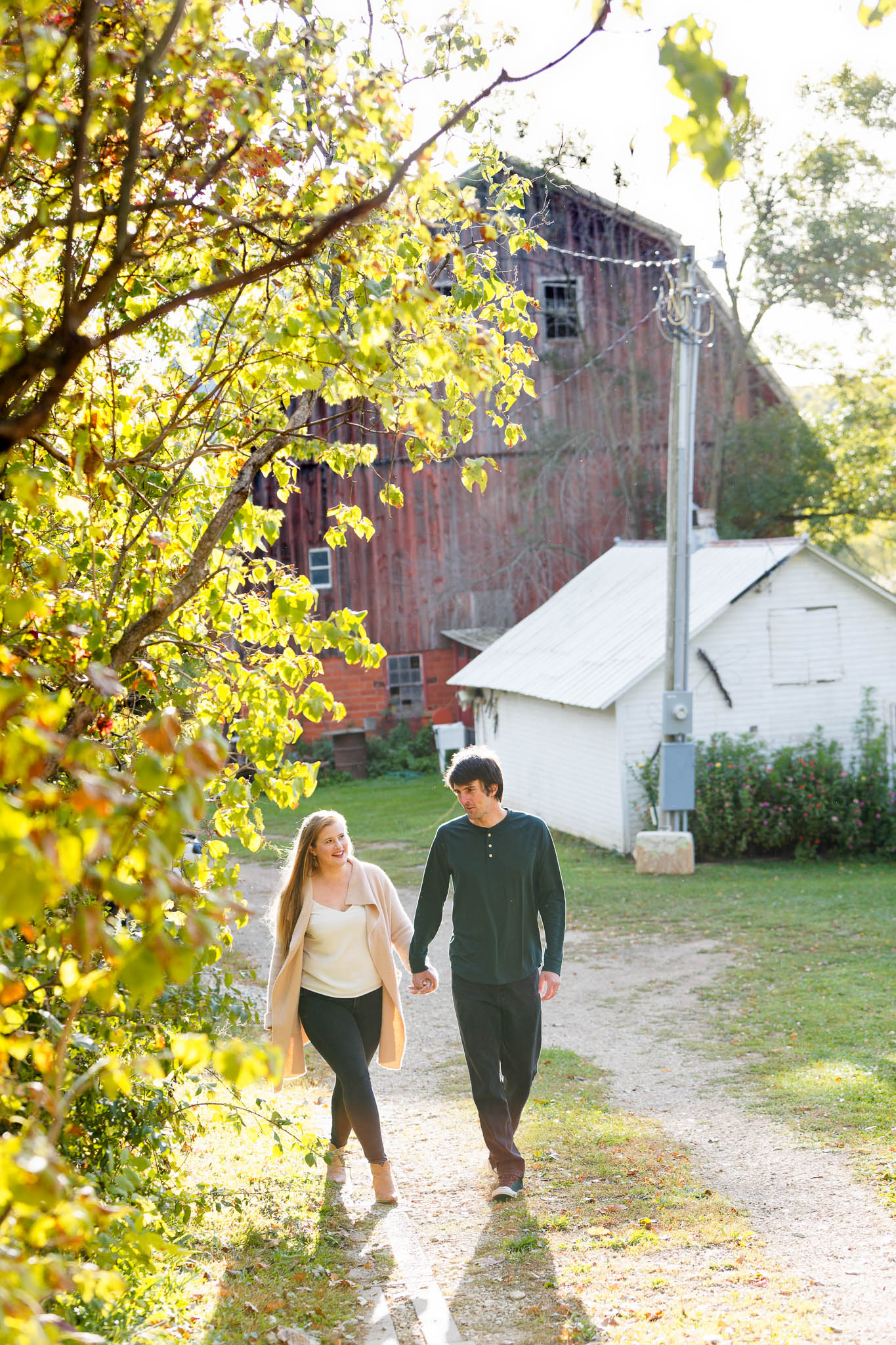 fall engagement photo shoot with red barn in the back
