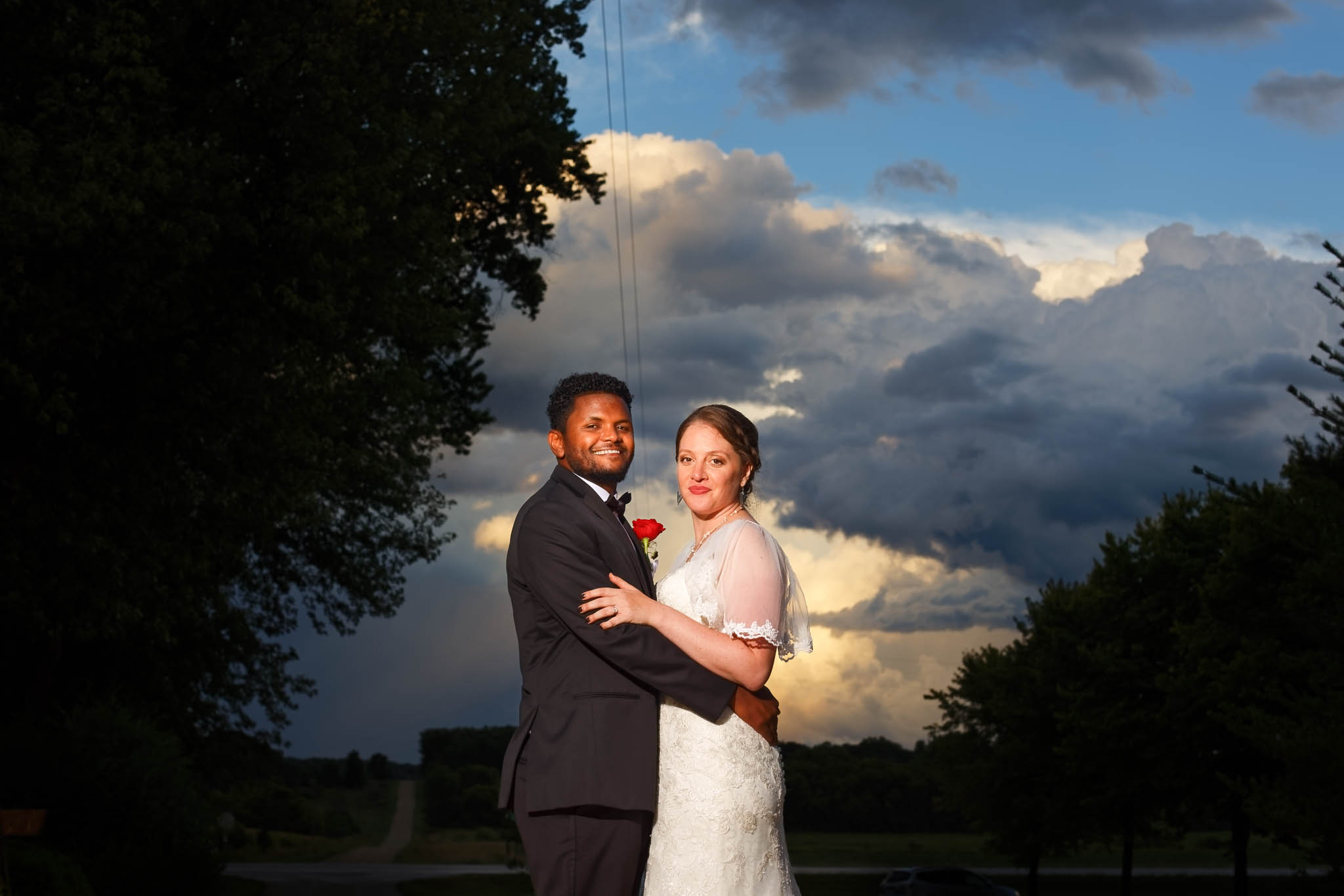 bride and groom in front of clouds