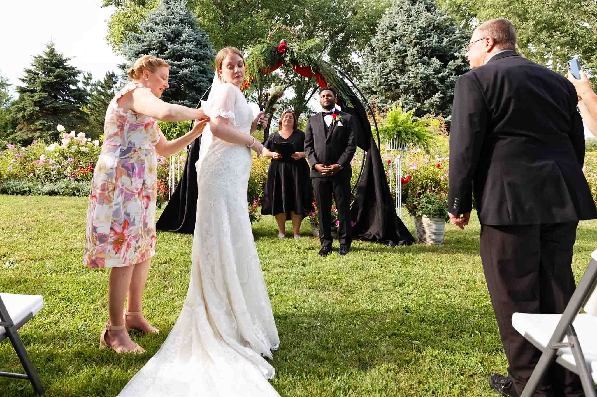 bride having ssue with dress tangled with buttons