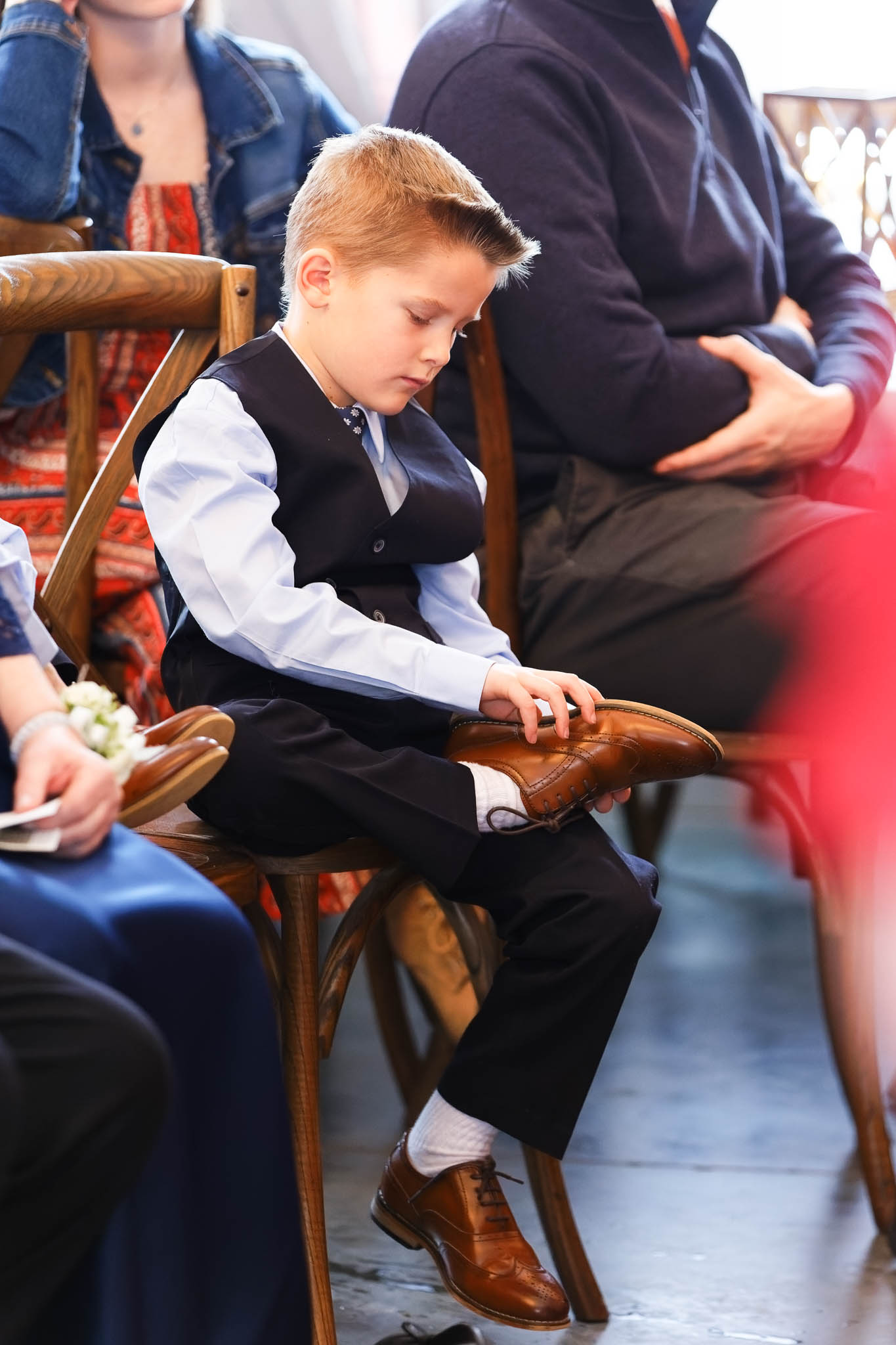 Kids looking at the back of his shoes during the ceremony