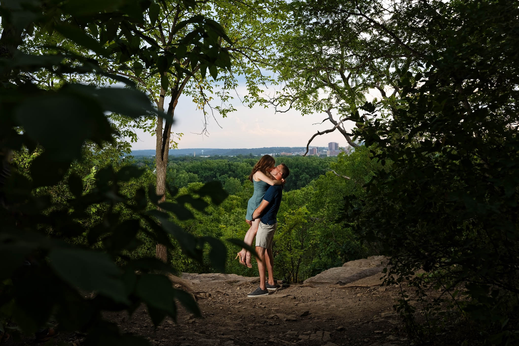 Couple kissing at Wahe Hill Park top of the Bluff view on the Met city in the background