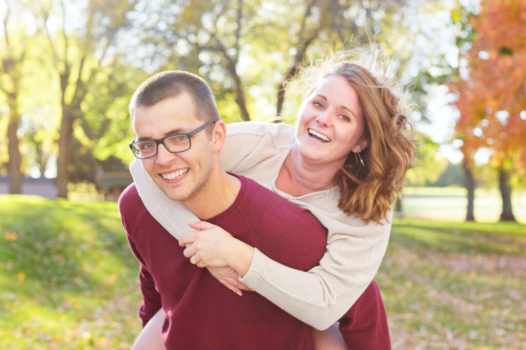 Happy couple playing and kissing with love during engagement session Rochester IBM park-2