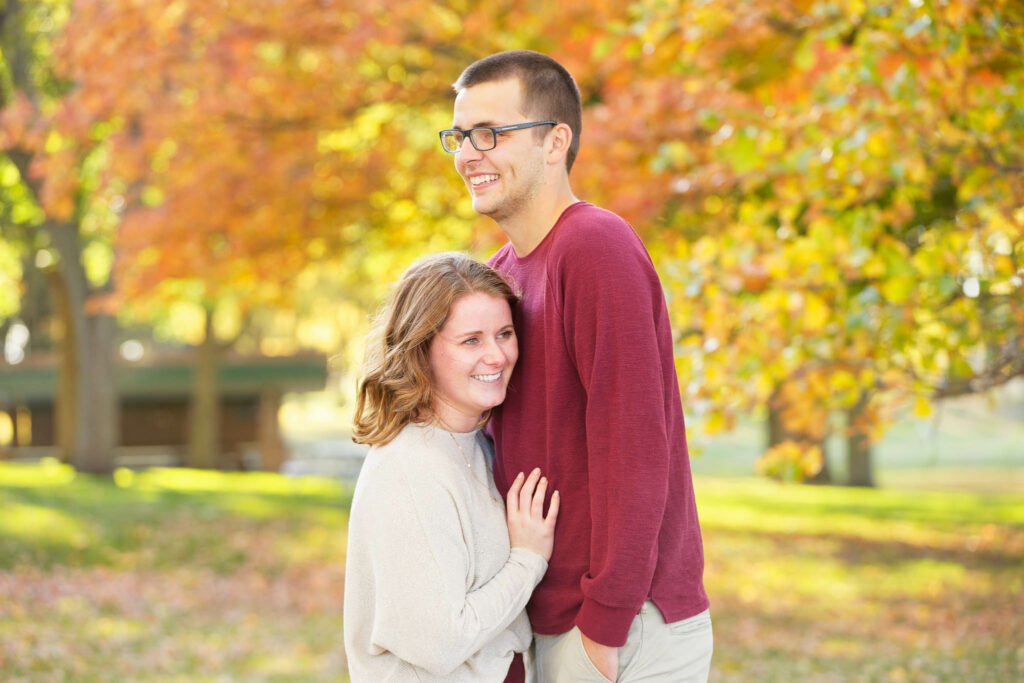 Happy couple playing and kissing with love during engagement session Rochester IBM park-3