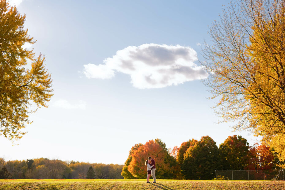 Happy couple playing and kissing with love during engagement session Rochester IBM park-5