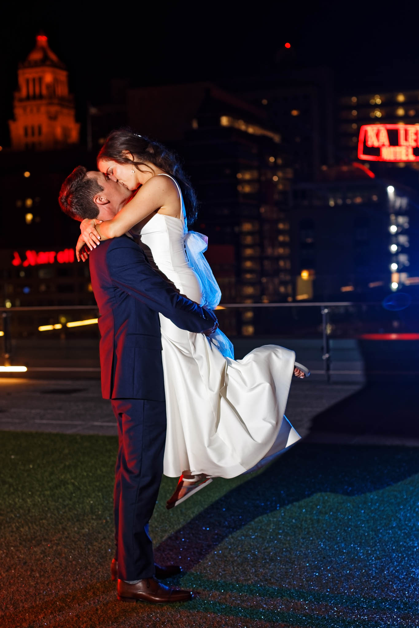 night portrait of newly married couple with view on Rochester city plummer building carillon and the Kahler Grand Hotel neon Sign-2
