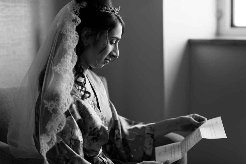Black-and-white photo of the bride, Reading a letter at Kahler Grand Hotel