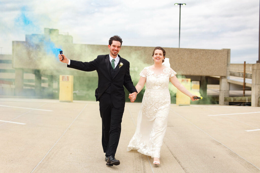 Creative image of the bride and groom playing with color smoke bombs