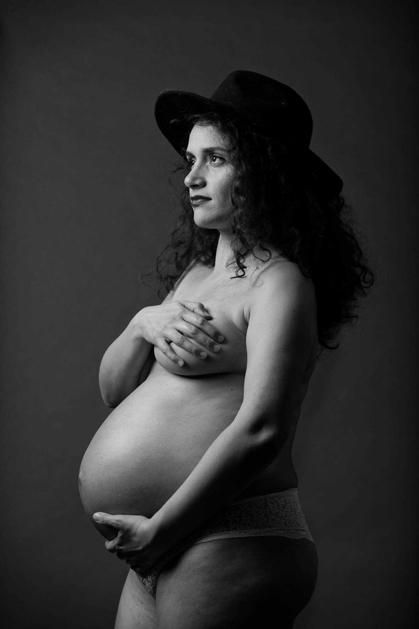 Studio Maternity photo session black background and hat