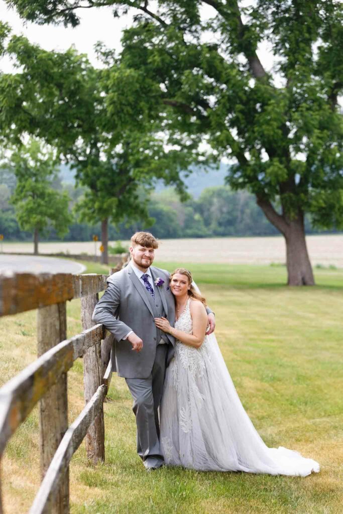 043-Right and groom Photo with the fence at Mayowood stone barn_