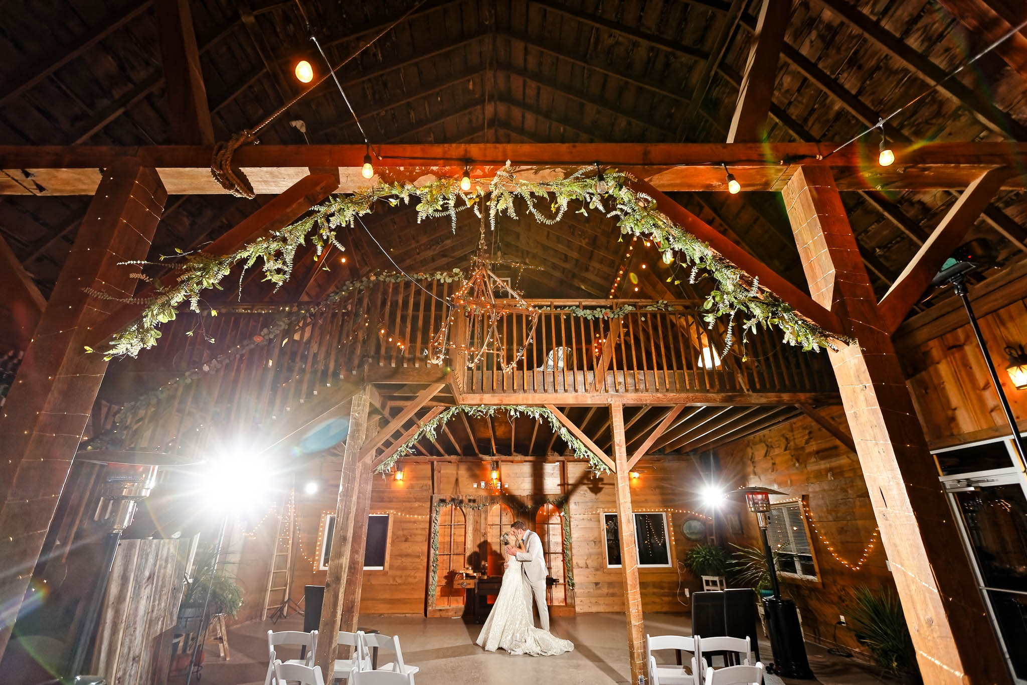 wide view on pond vew barn with bride and groom