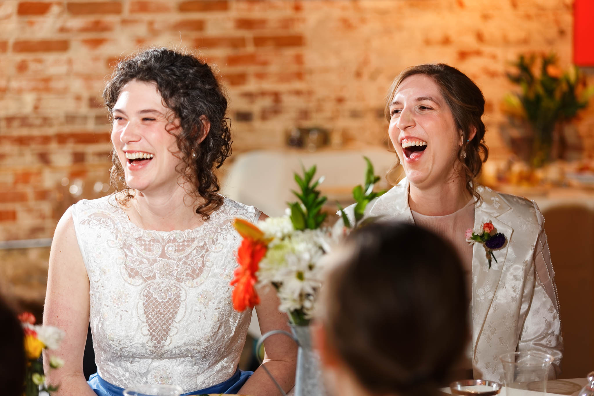 candid reaction of the bride and bride during toasts