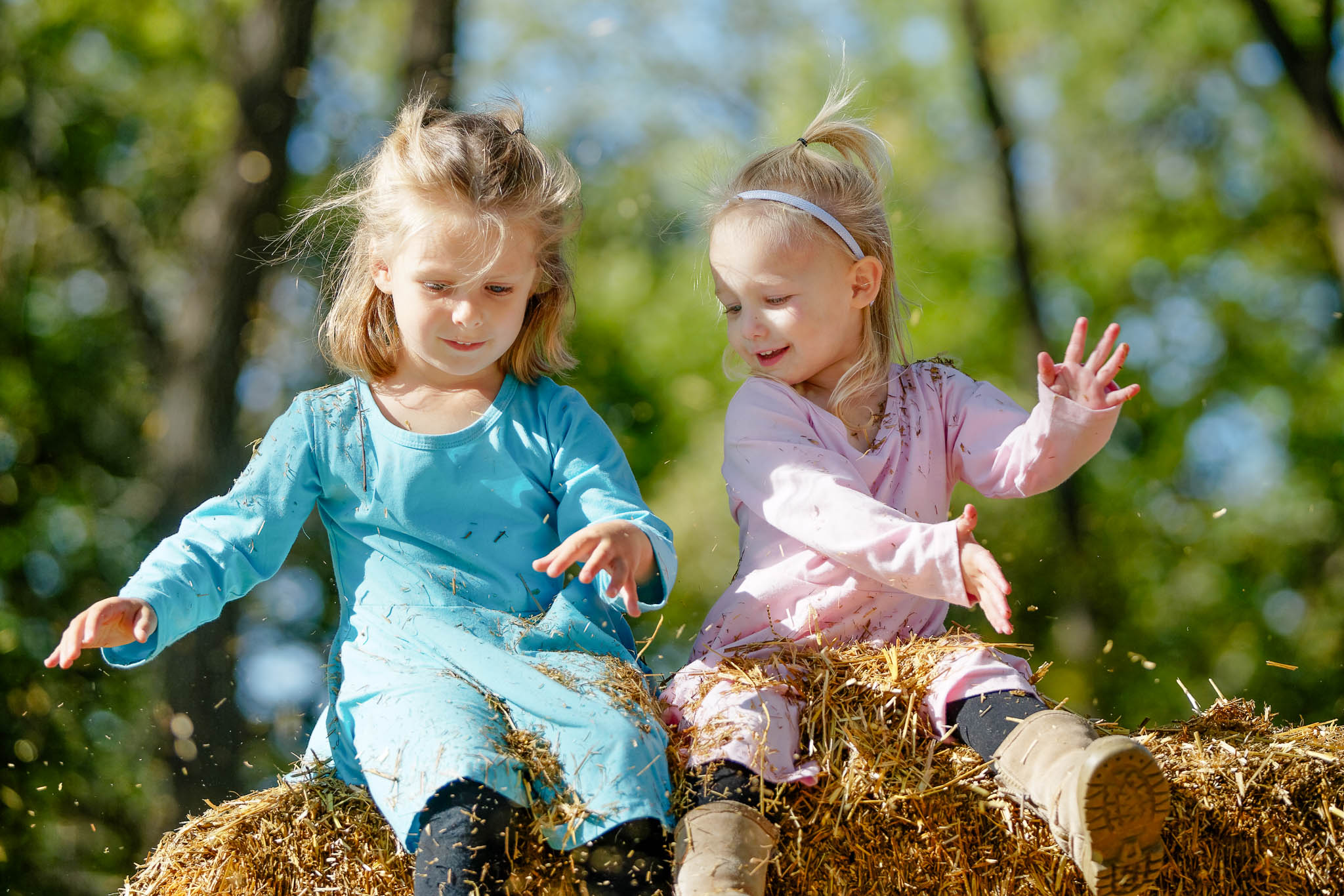 sisters toddlers playing with straw-2