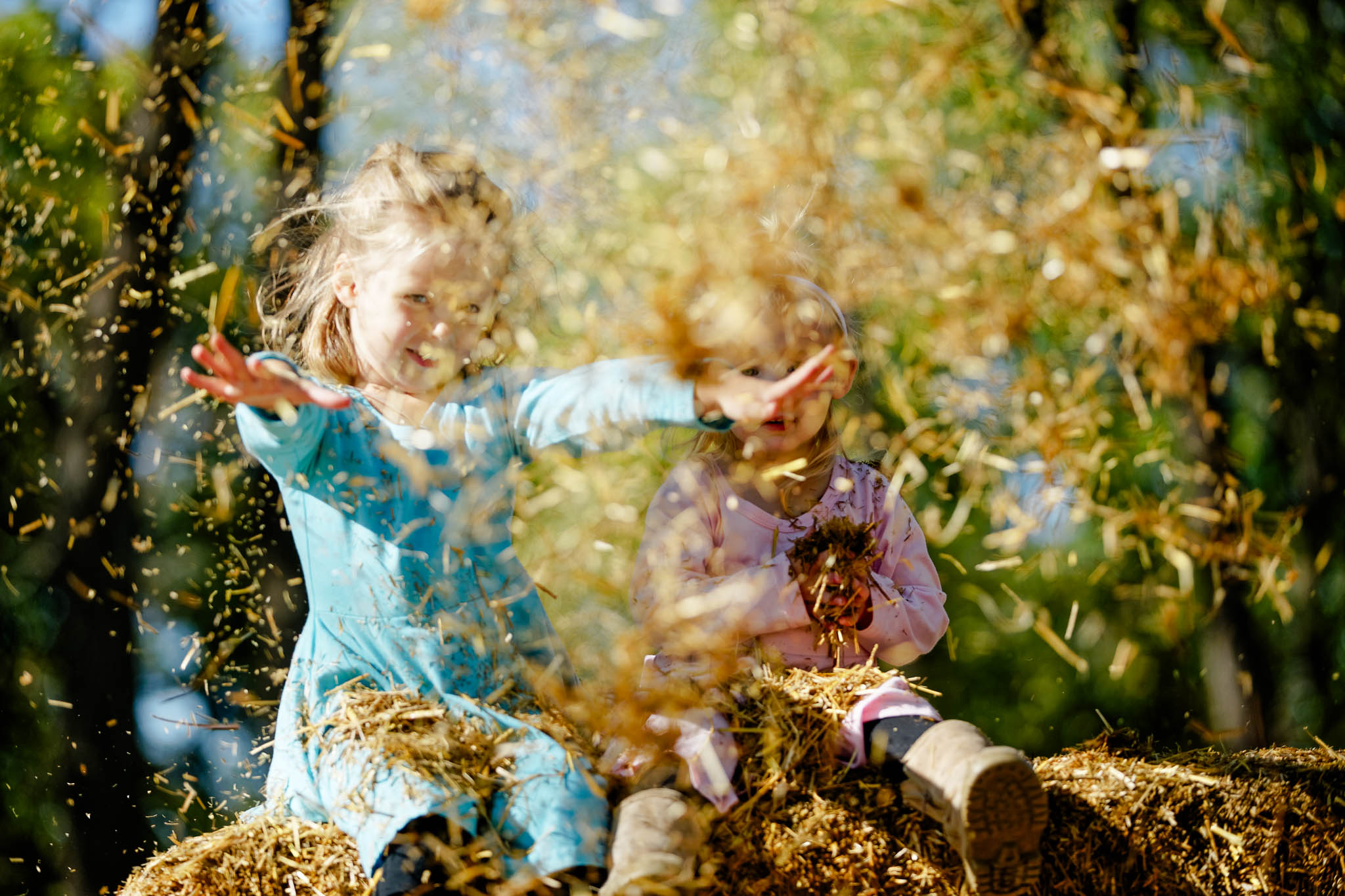 sisters toddlers playing with straw