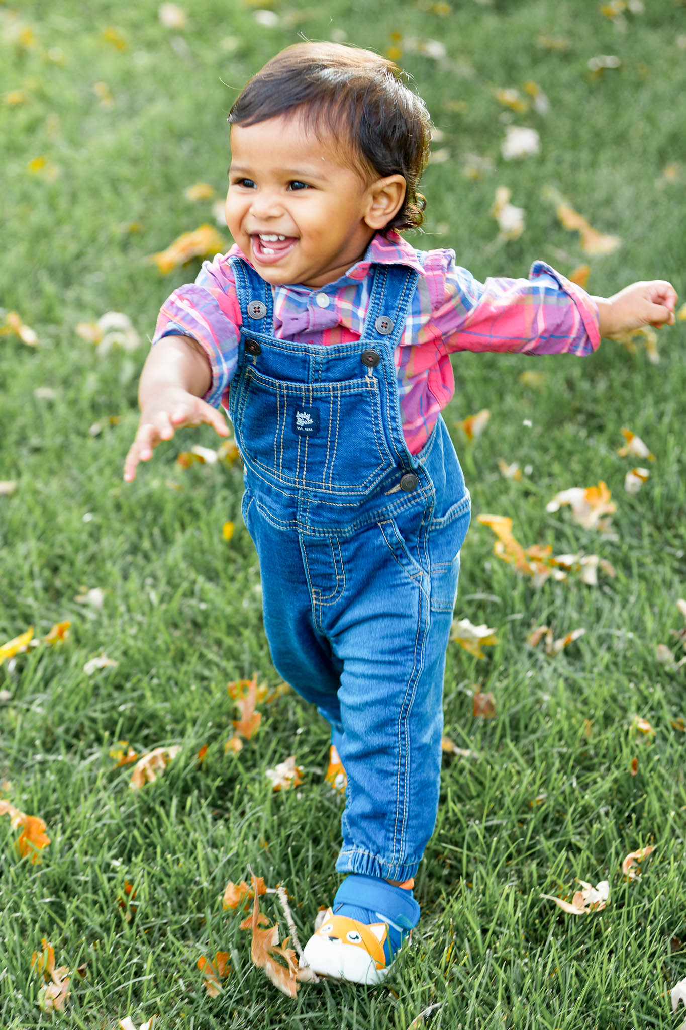 toddler walking and laughting in lawn