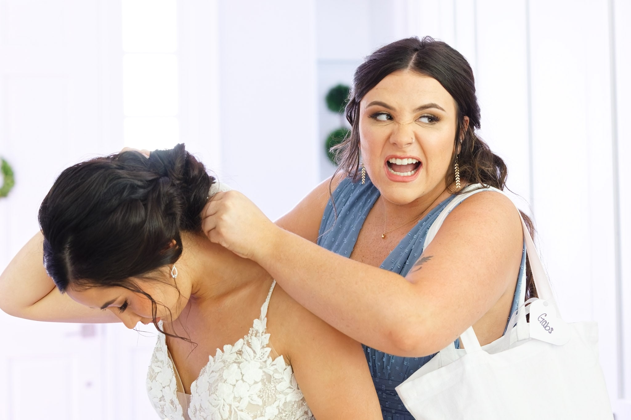 bridesmaid fixing the veil on the bride