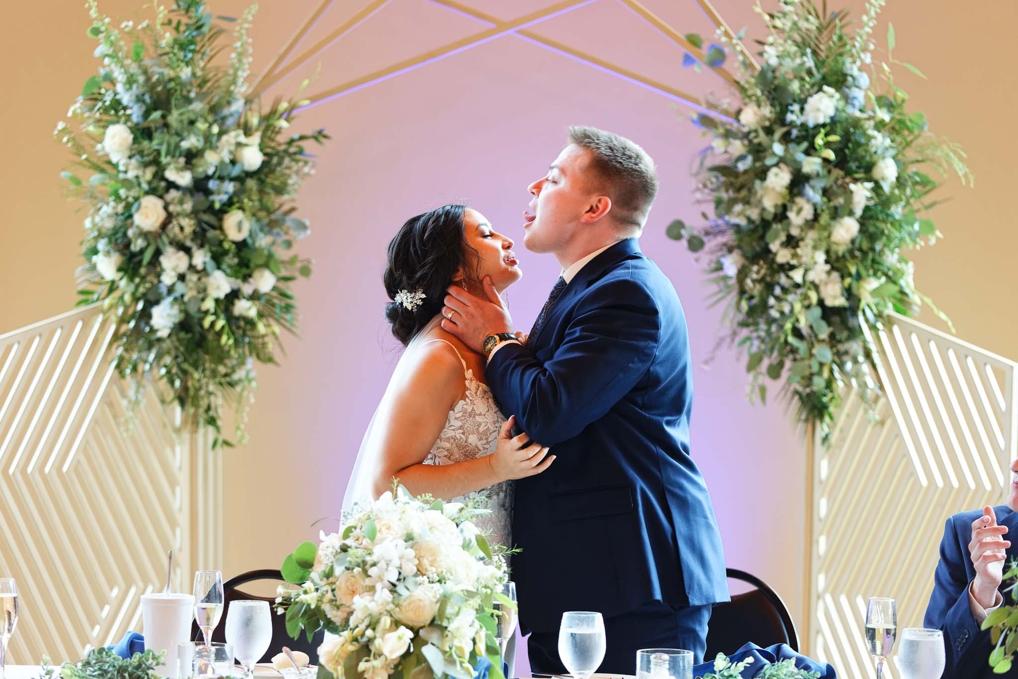 silly groom kissing bride dinner