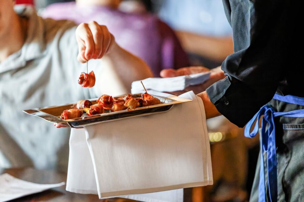 waiter offering food to wedding guests