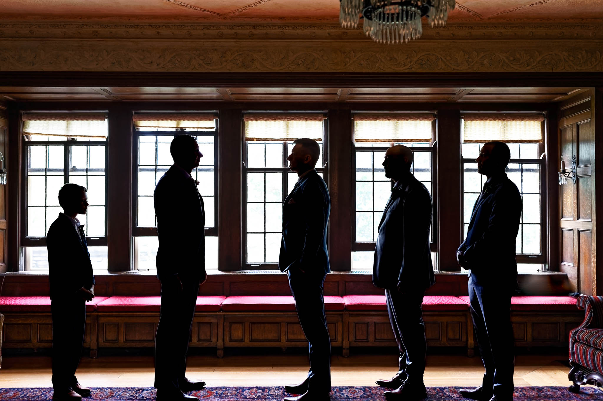 creative group photos of goorm and groomsmen at the plummer house living room