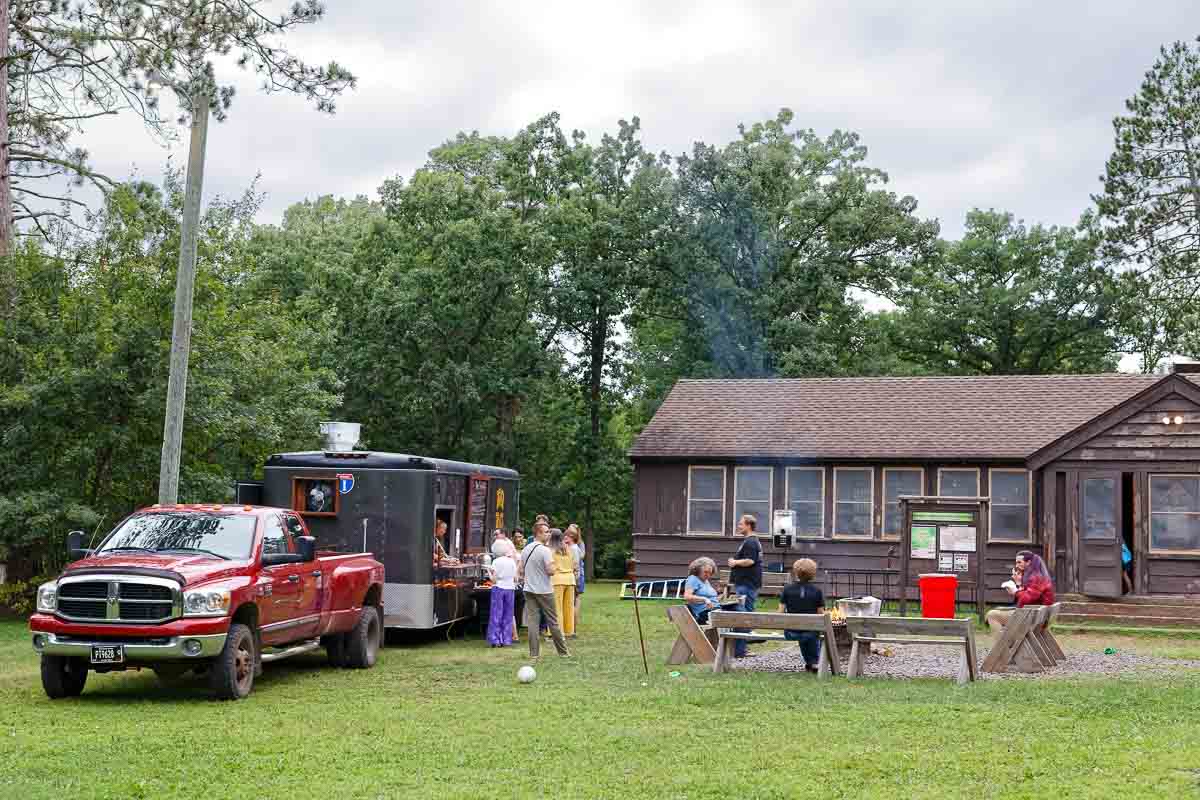 taco food truck at outdoor minnesota state park wedding, guests eating outside at sunset, candid documentary photography