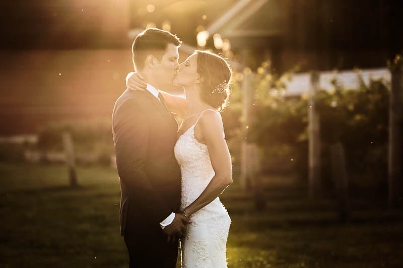 sunset pic of bride and groom kissing four daughters moody