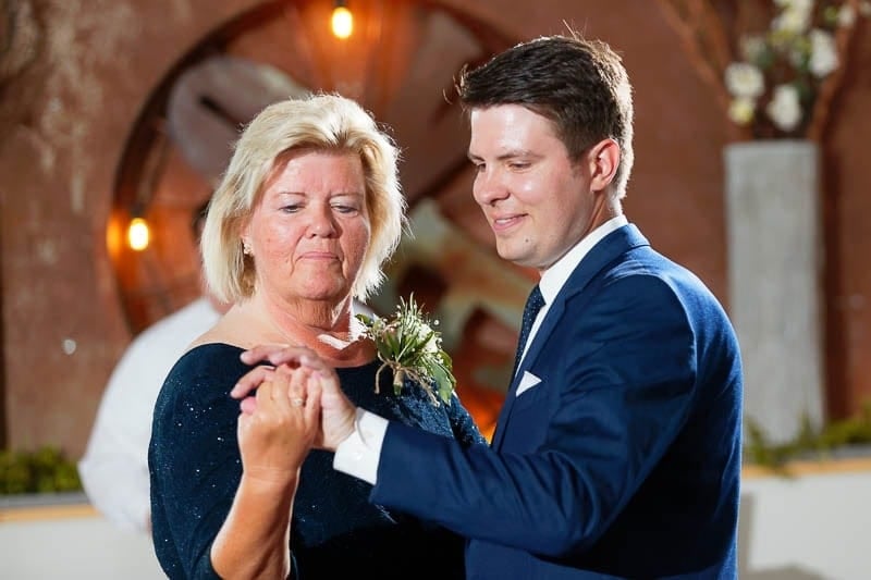 mother dancing with the groom at looking at his ring