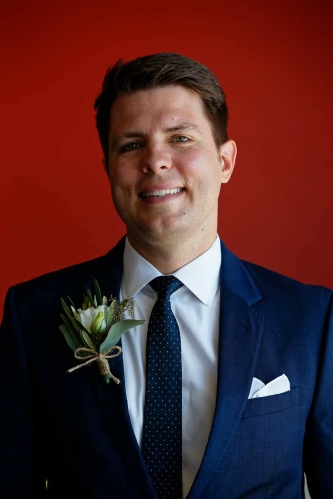  portrait of groom red background