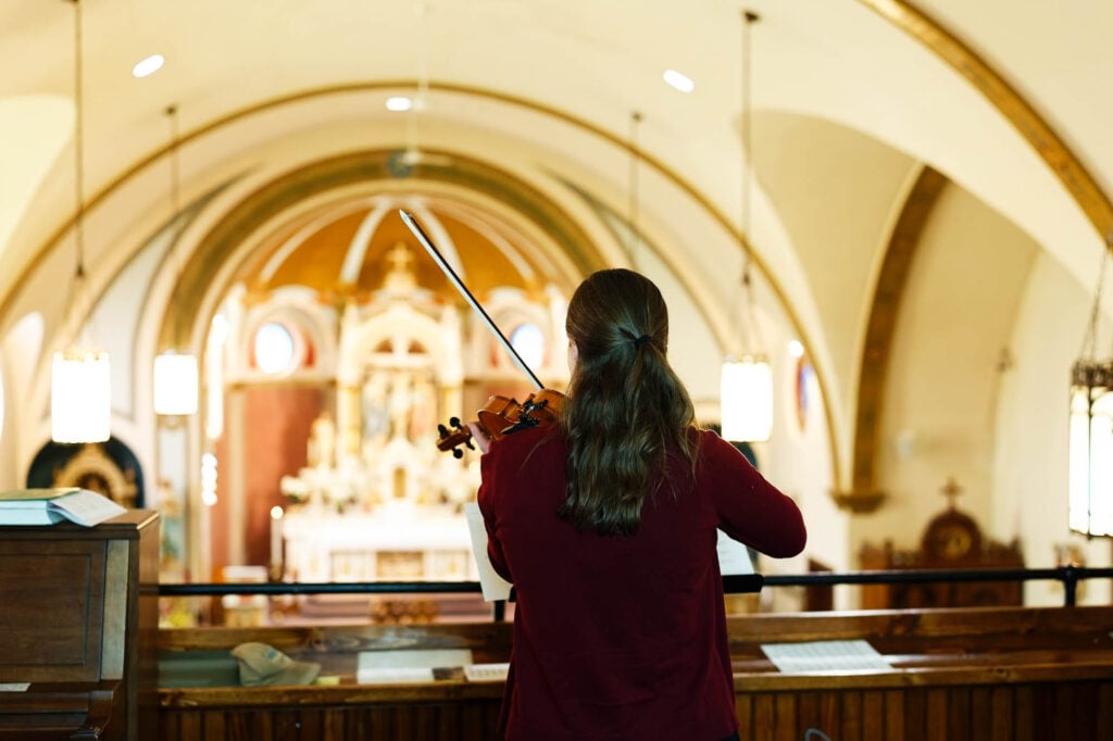 Musician playing the violin on the balcony above the church