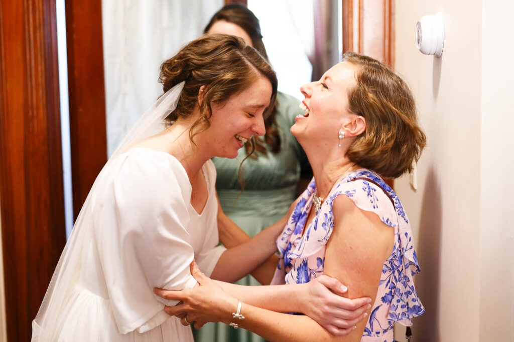 The bride laughing heartily with a guest