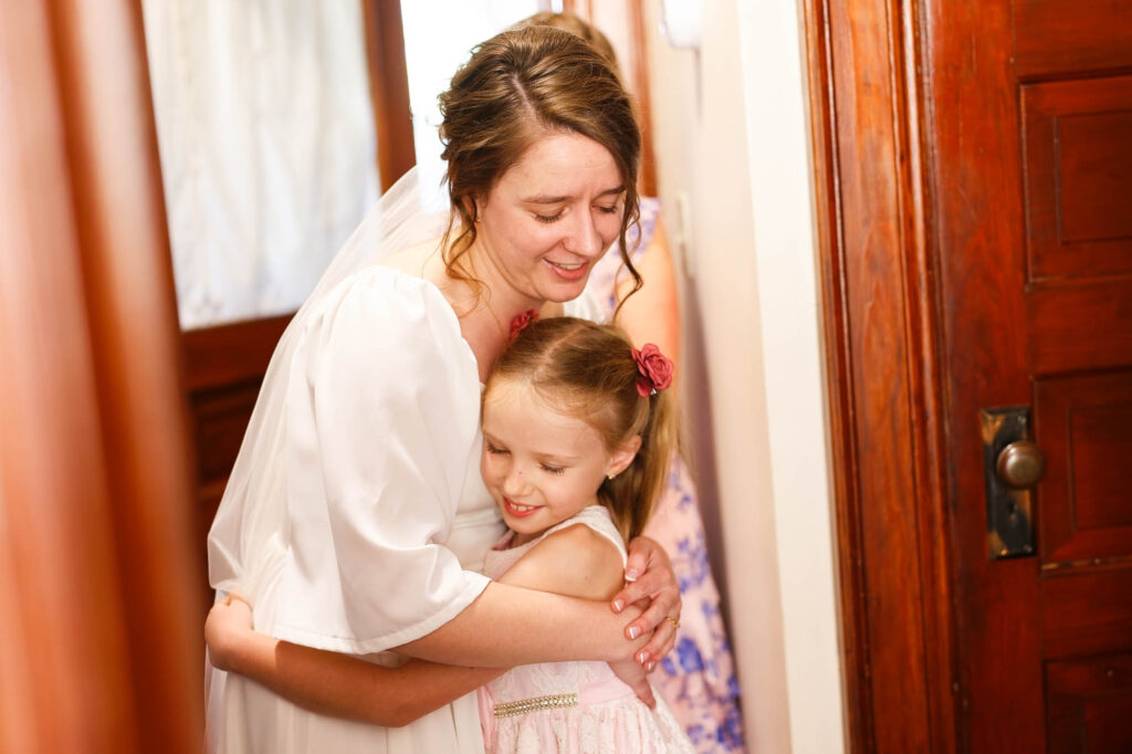 The bride hugging a little girl who could be her flower girls