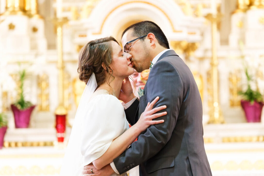 couple kissing at the end of the wedding ceremony at church