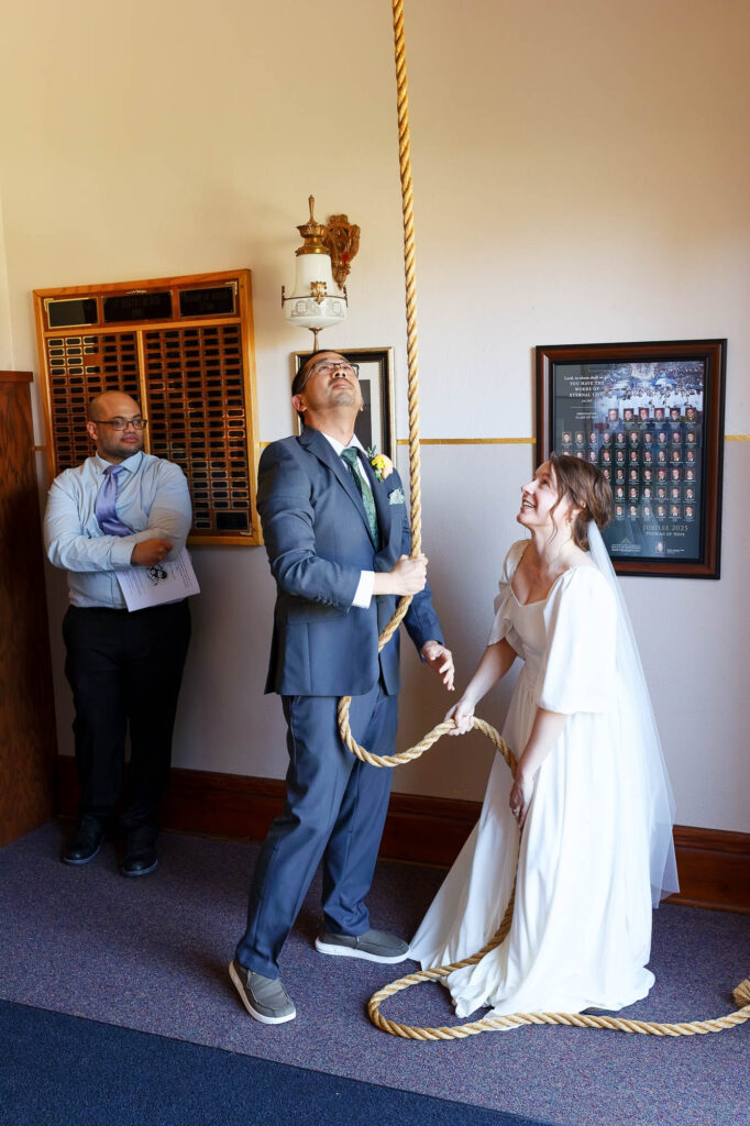 The newlyweds ringing the church bell at the end of the ceremony
