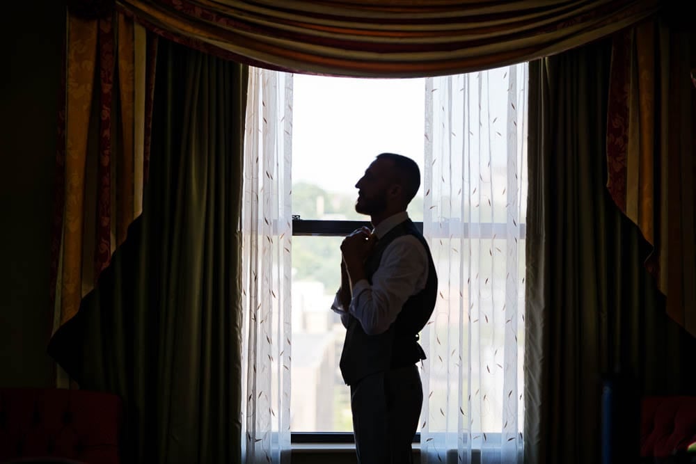 silhouette of the groom in front the window