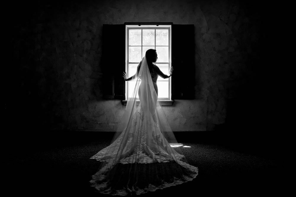 artistic black and white picture of bride silhouette in her wedding dress town country club