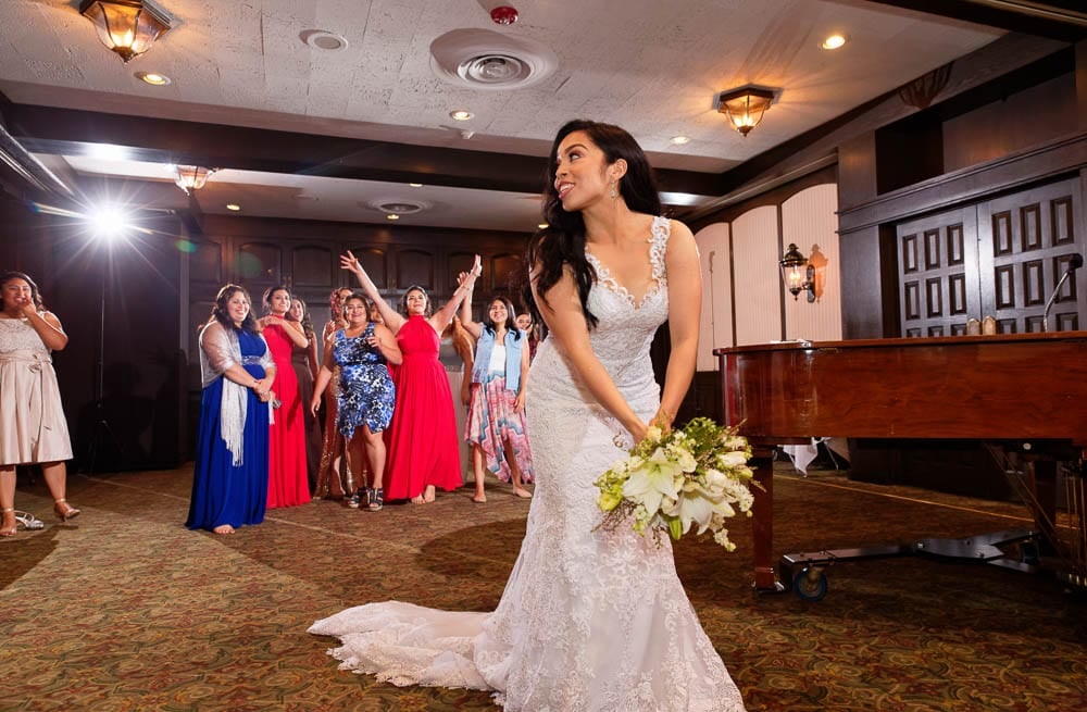 bride tossing bouquet with Town and Country Club MN in backdrop