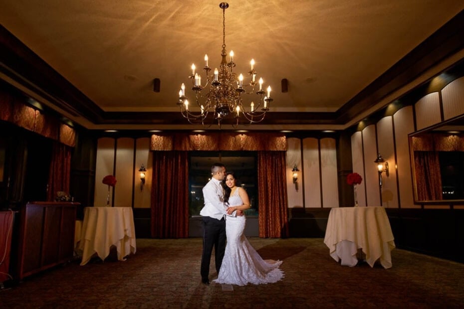 majestic shot of bride and groom with chandelier in ample halls at the Town and Country Club Saint Paul